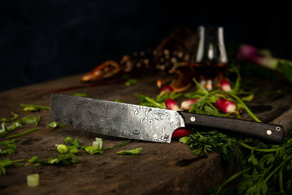 Chef's knife in Damascus steel on a wooden worktop