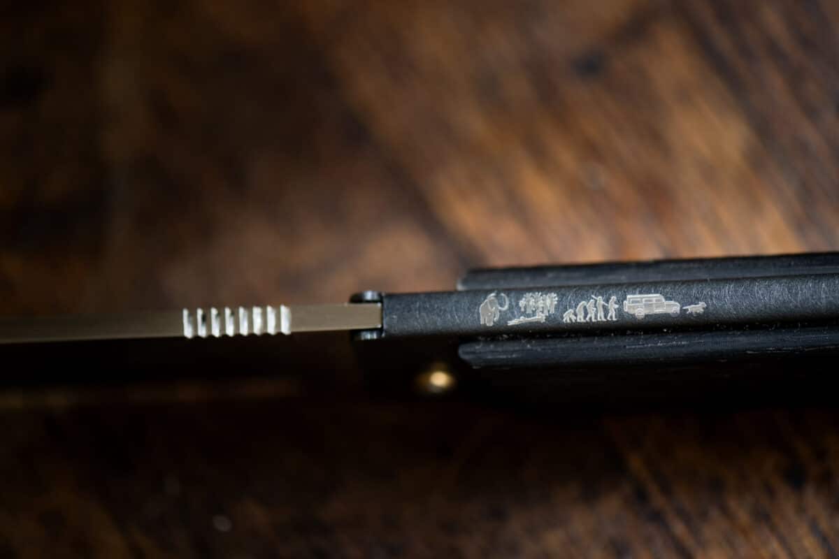 OK6 Vue détaillée d'un manche de couteau Morta avec une série de gravures représentant l'histoire de Couteaux Morta, gravés directement sur la surface du manche.